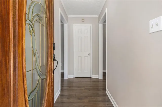 a view of a hallway with wooden floor and door