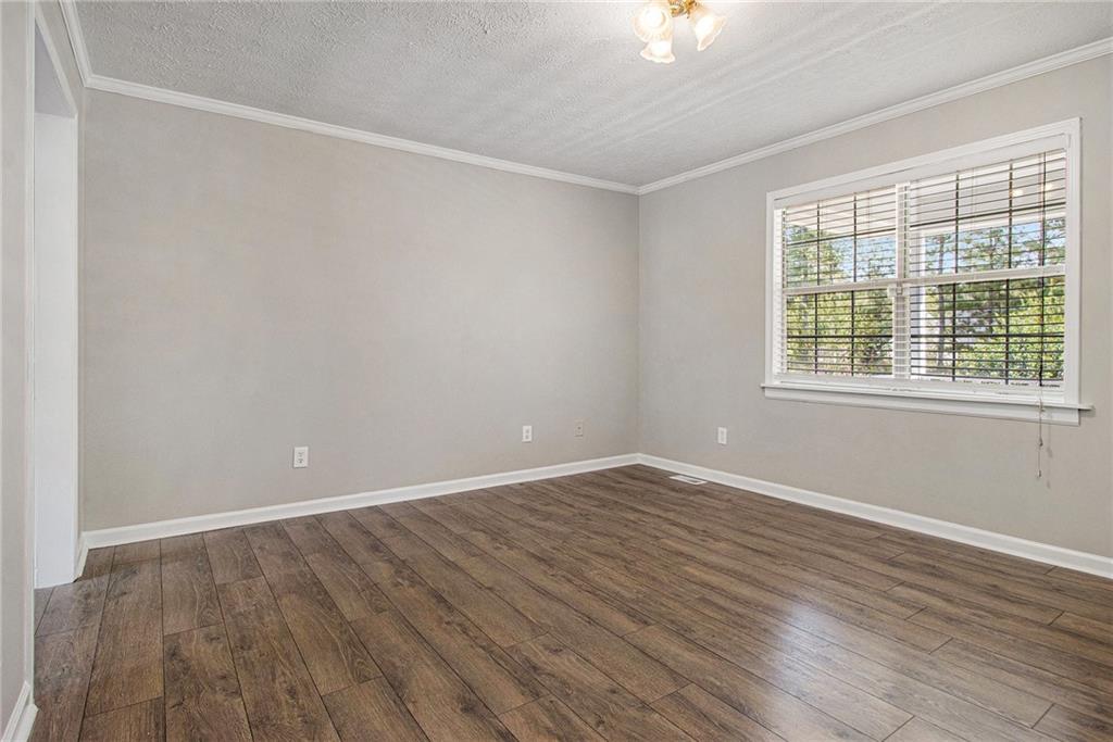 150 Dub Walker Road Jackson, GA 30233 - Photo 6 of 32 a view of an empty room with wooden floor and a window