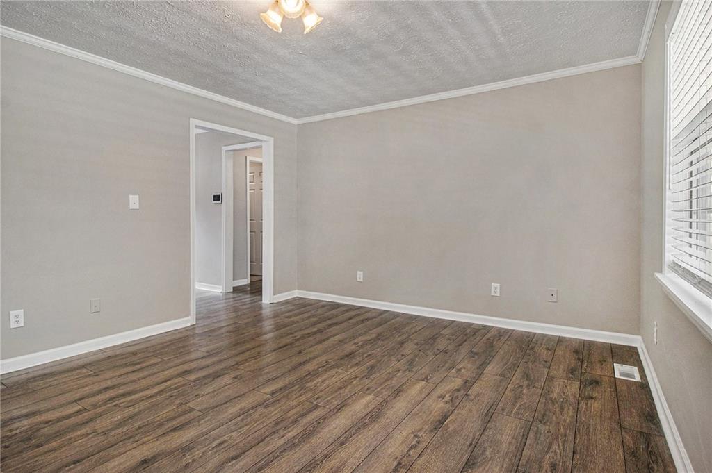150 Dub Walker Road Jackson, GA 30233 - Photo 7 of 32 a view of an empty room with wooden floor and a window