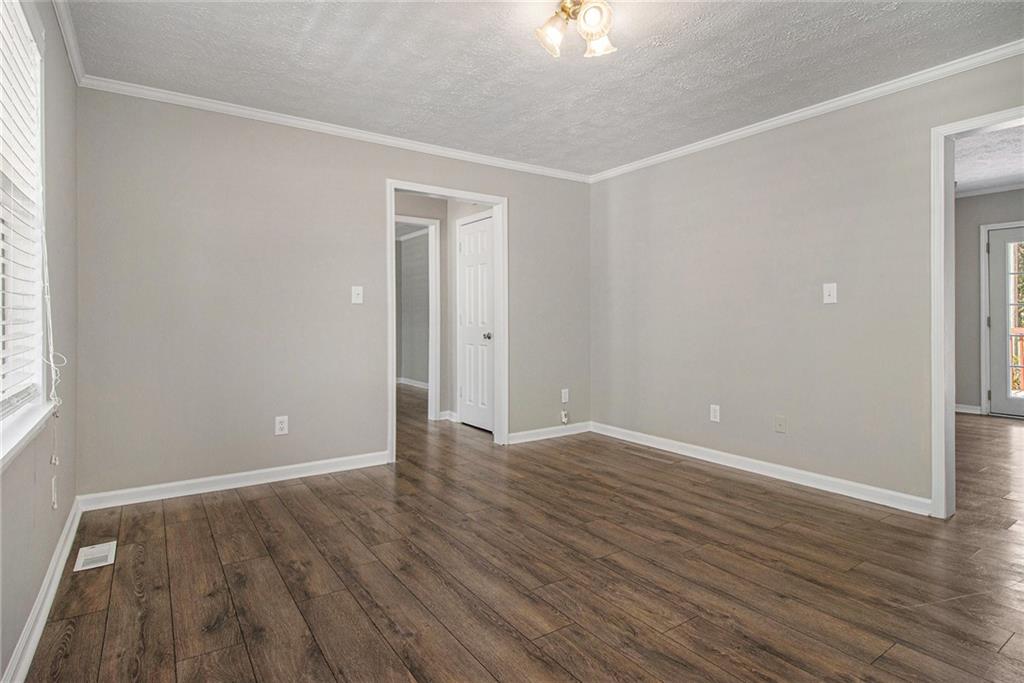 150 Dub Walker Road Jackson, GA 30233 - Photo 8 of 32 a view of an empty room with wooden floor and a window