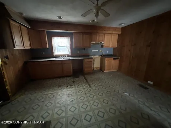 a kitchen with granite countertop a sink window and stainless steel appliances