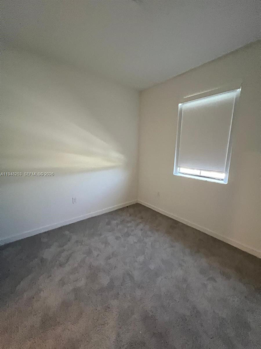12908 Southwest 233rd Terrace, Unit 12908 Homestead, FL 33032 - Photo 13 of 23 an empty room with a workbench