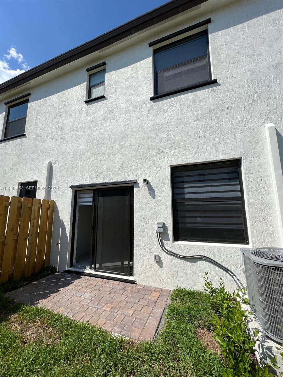 12908 Southwest 233rd Terrace, Unit 12908 Homestead, FL 33032 - Photo 2 of 23 a backyard of a house with fireplace and tv