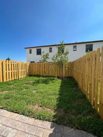 a view of a backyard with wooden fence