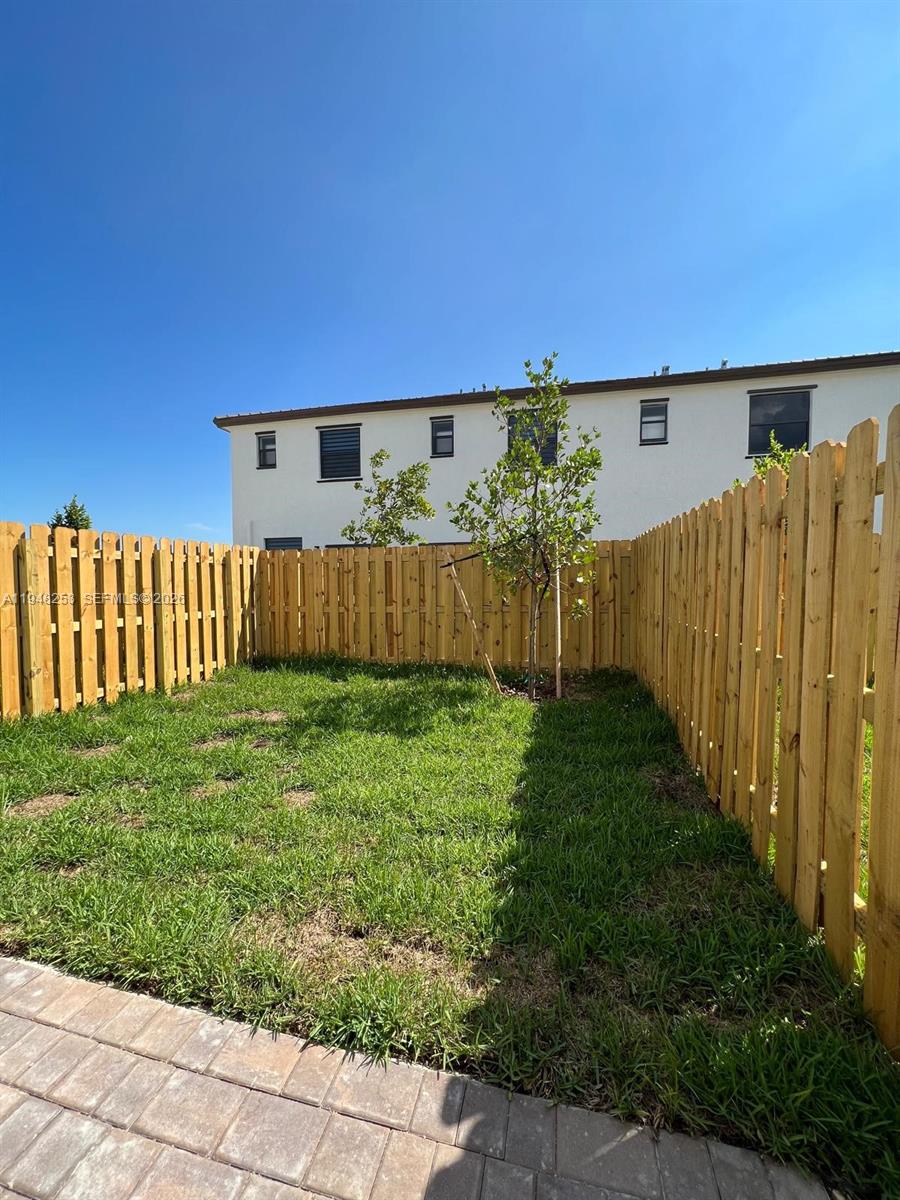 12908 Southwest 233rd Terrace, Unit 12908 Homestead, FL 33032 - Photo 3 of 23 a view of a backyard with wooden fence