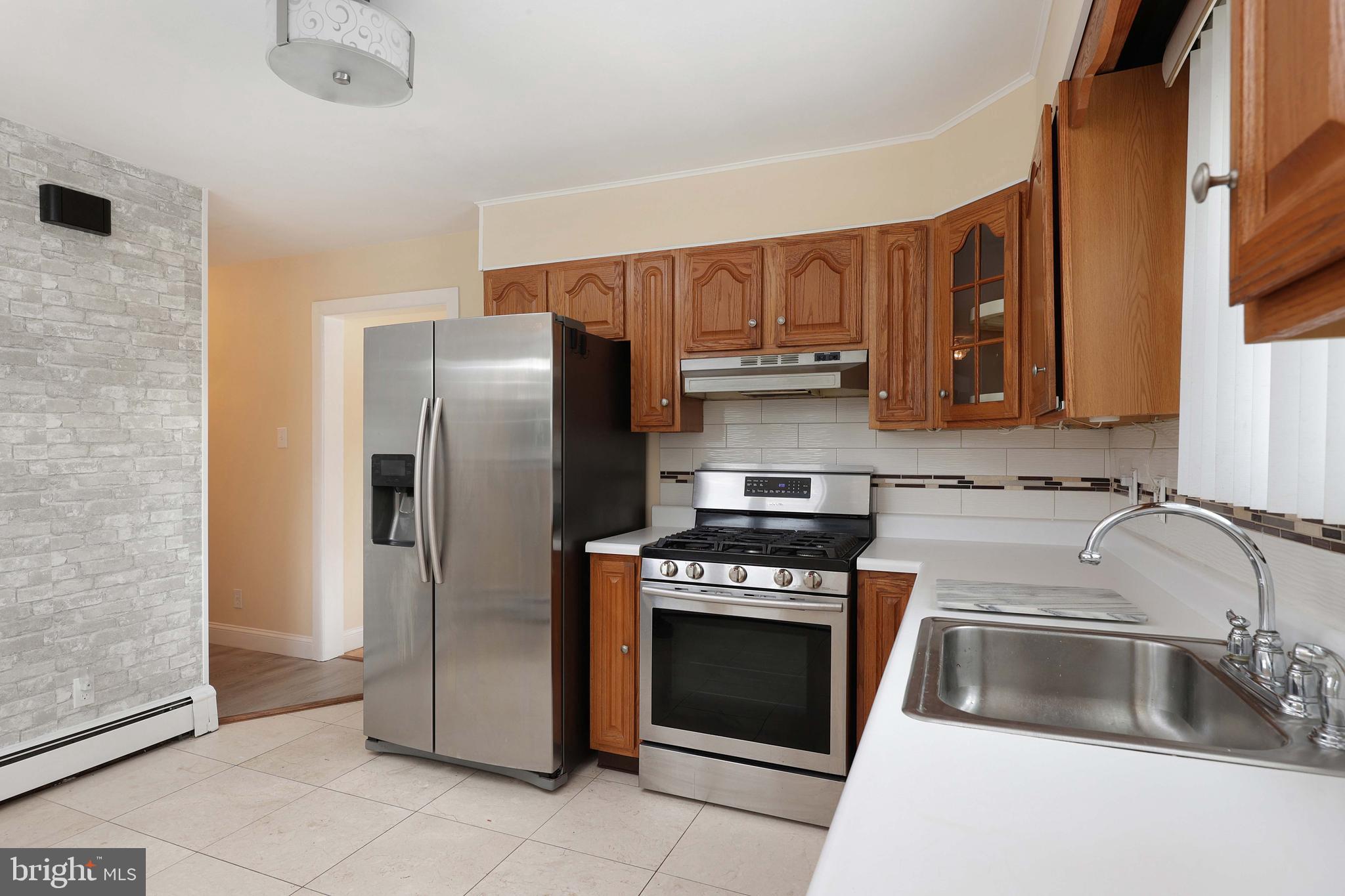 105 Kentucky Avenue Hamilton, NJ 08619 - Photo 11 of 29 a kitchen with stainless steel appliances a stove a sink and a refrigerator
