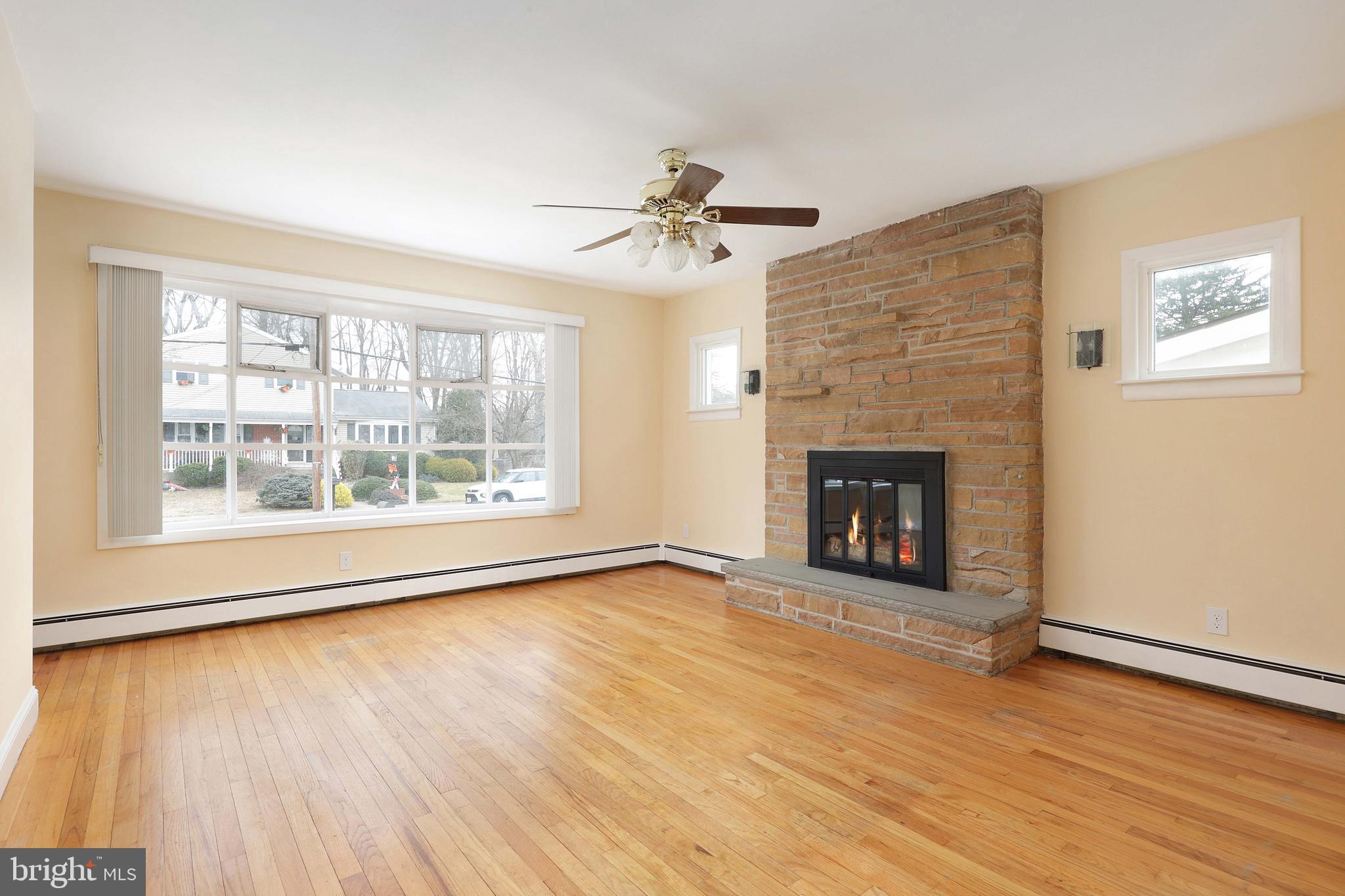 105 Kentucky Avenue Hamilton, NJ 08619 - Photo 6 of 29 an empty room with wooden floor fireplace and windows