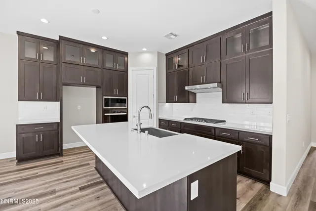 a large kitchen with kitchen island a sink stainless steel appliances and cabinets