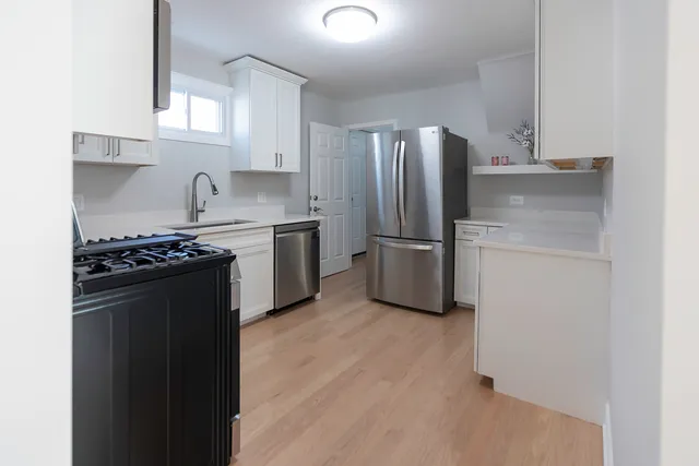 a kitchen with stainless steel appliances granite countertop a refrigerator stove and sink