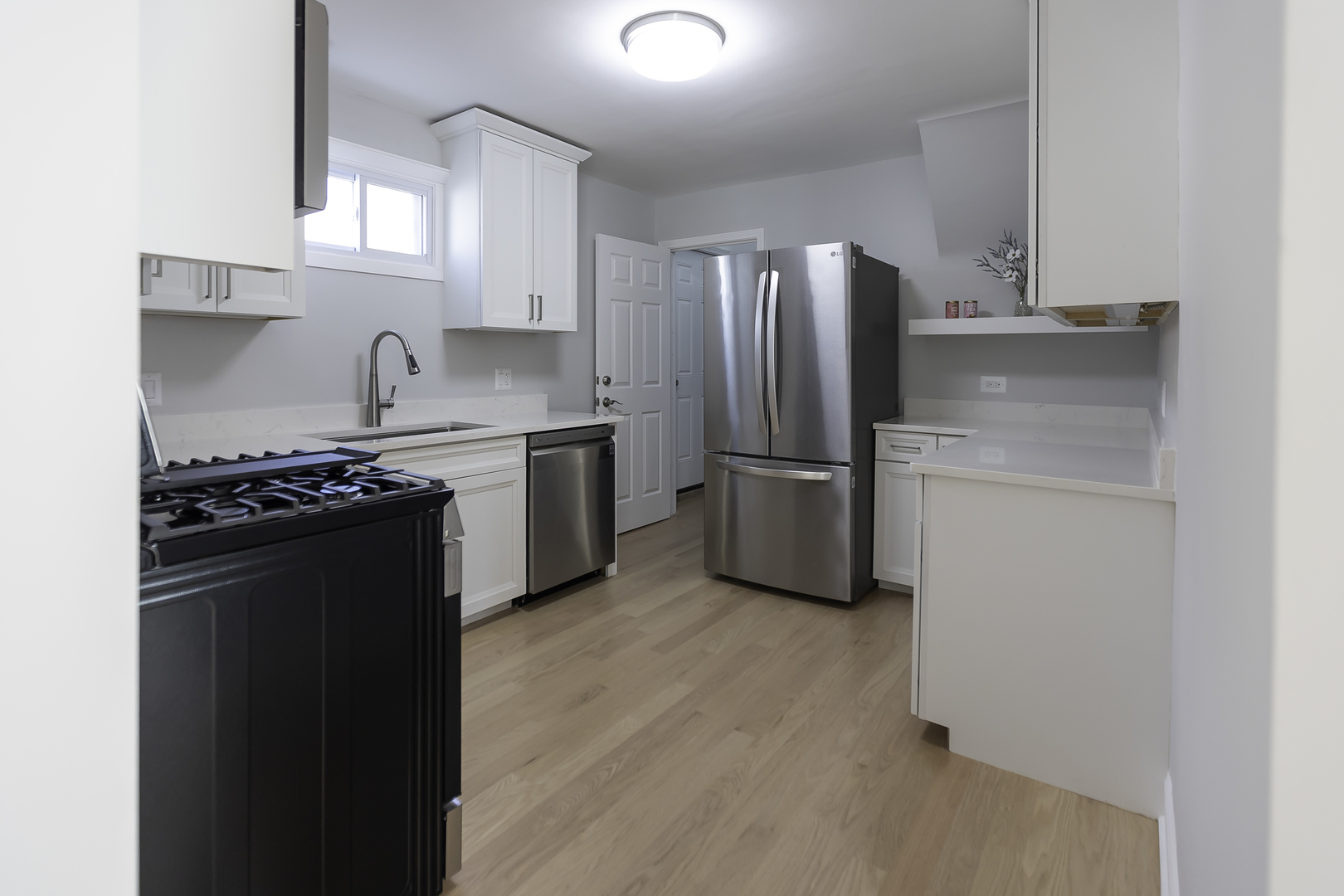 3948 North Olcott Avenue, Unit 1 Chicago, IL 60634 - Photo 2 of 8 a kitchen with stainless steel appliances granite countertop a refrigerator stove and sink