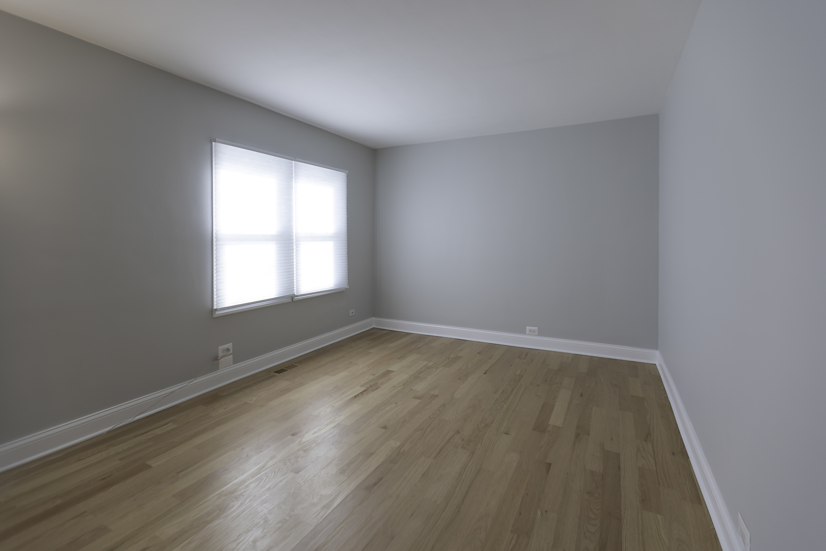 3948 North Olcott Avenue, Unit 1 Chicago, IL 60634 - Photo 5 of 8 a view of an empty room with wooden floor and a window