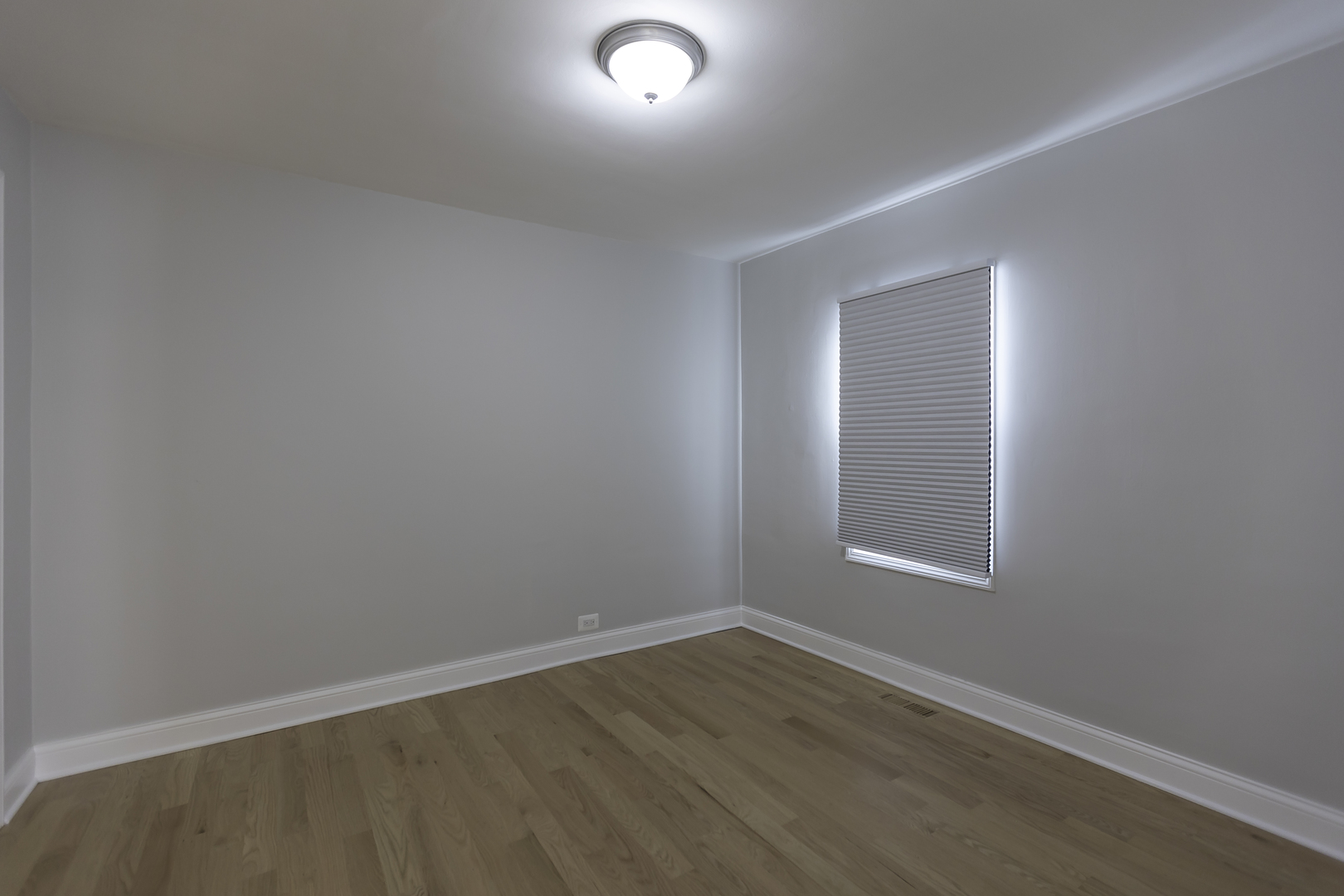 3948 North Olcott Avenue, Unit 1 Chicago, IL 60634 - Photo 6 of 8 a view of an empty room with wooden floor and a window