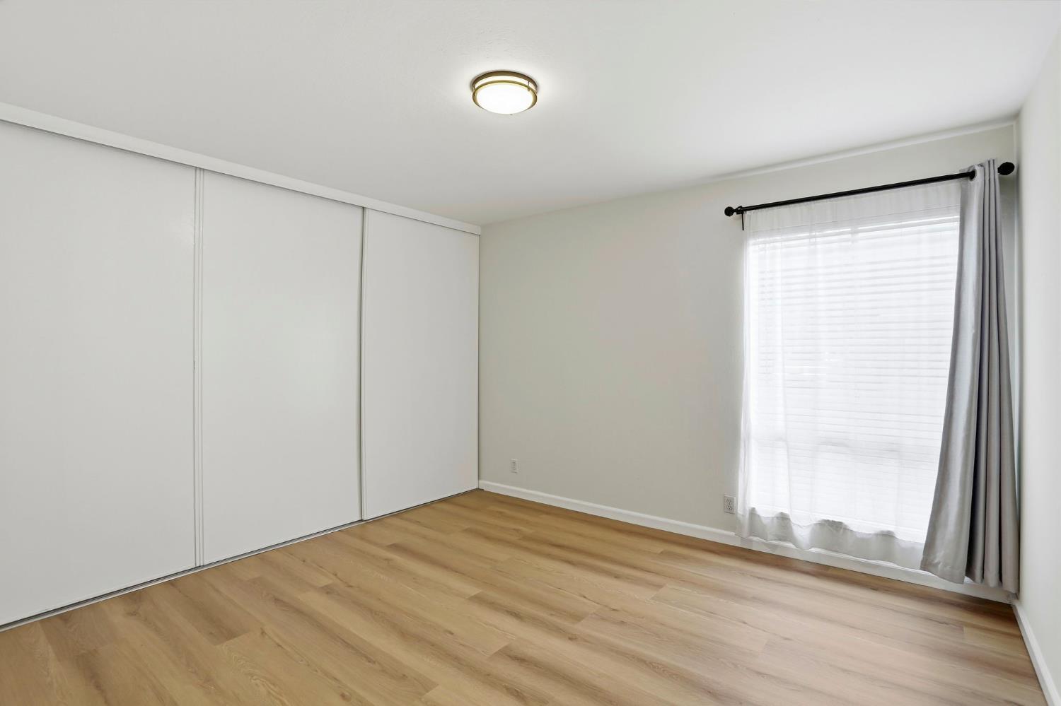 9005 Alcosta Boulevard, Unit 215 San Ramon, CA 94583 - Photo 13 of 30 a view of empty room with wooden floor and fan