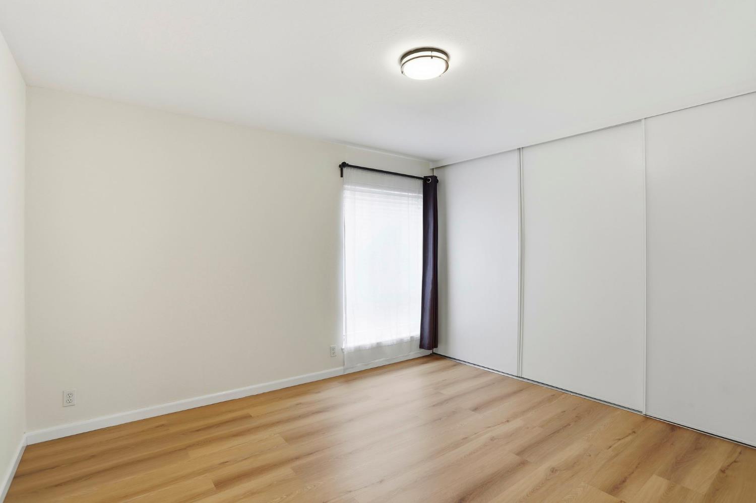 9005 Alcosta Boulevard, Unit 215 San Ramon, CA 94583 - Photo 15 of 30 an empty room with wooden floor and windows