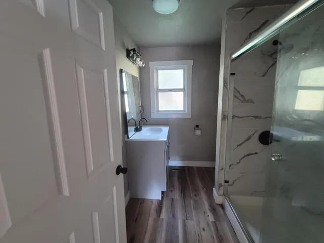 a bathroom with a sink and glass door shower