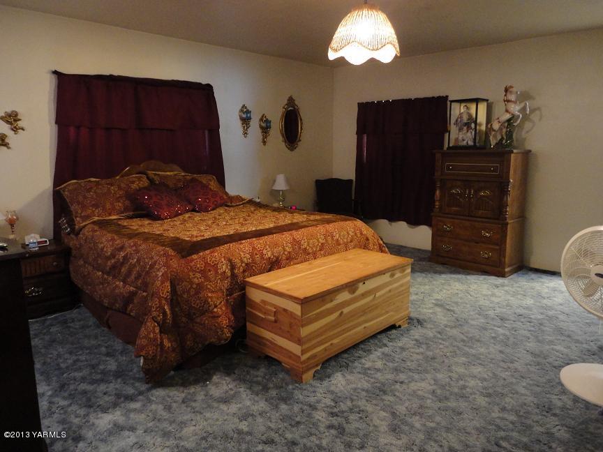 6408 Postma Road Yakima, WA 98901 - Photo 14 of 25 a bedroom with a bed and a dresser