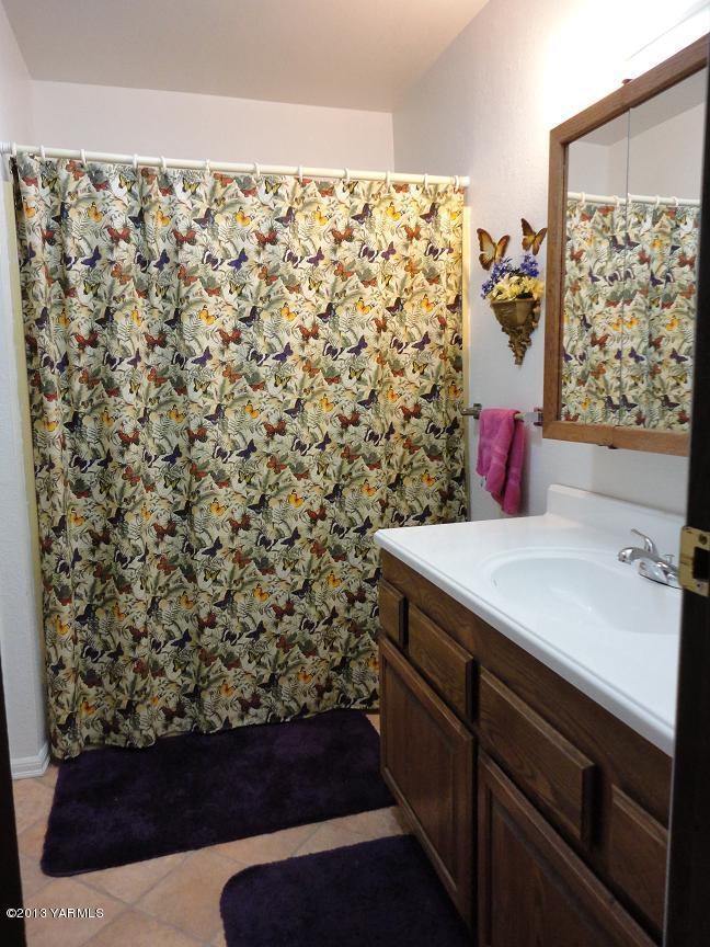 6408 Postma Road Yakima, WA 98901 - Photo 6 of 25 a bathroom with a sink and a shower curtain