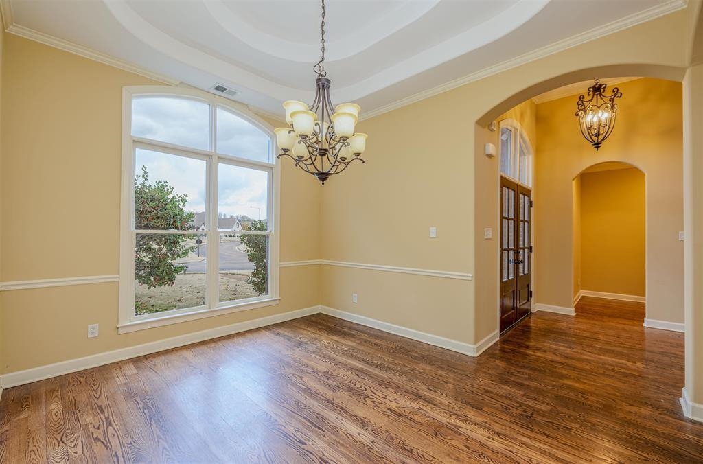 5380 Scarlet Ridge Drive Arlington, TN 38002 - Photo 5 of 35 Formal room featuring rich wood-finish flooring, an arched window, and a tray ceiling with crown molding