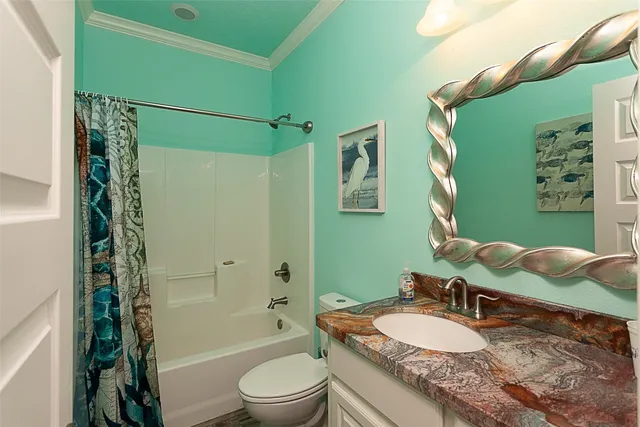 a bathroom with a granite countertop bathtub sink vanity mirror and toilet
