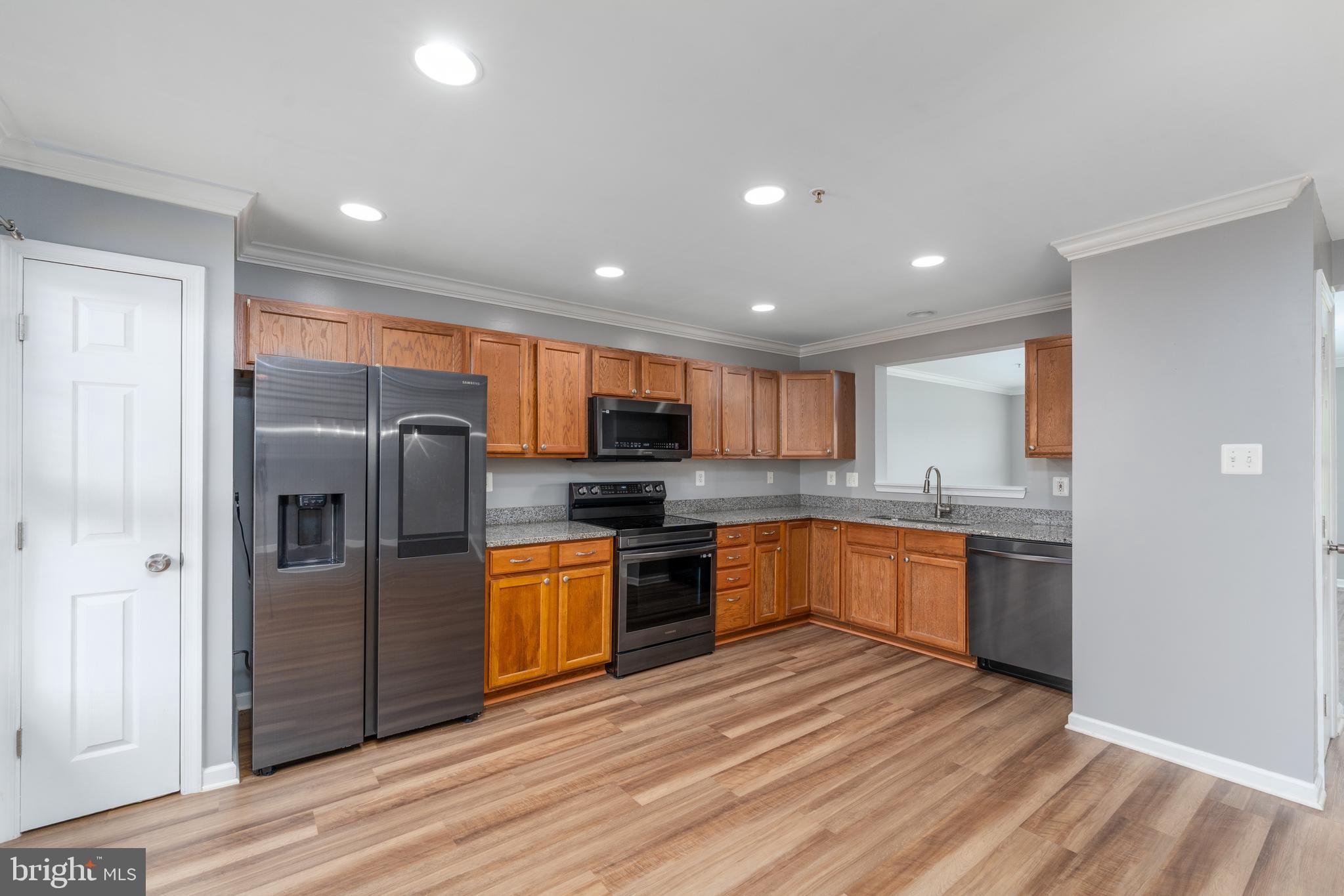9903 Decatur Road Baltimore, MD 21220 - Photo 3 of 37 a large kitchen with stainless steel appliances granite countertop a refrigerator and a stove top oven