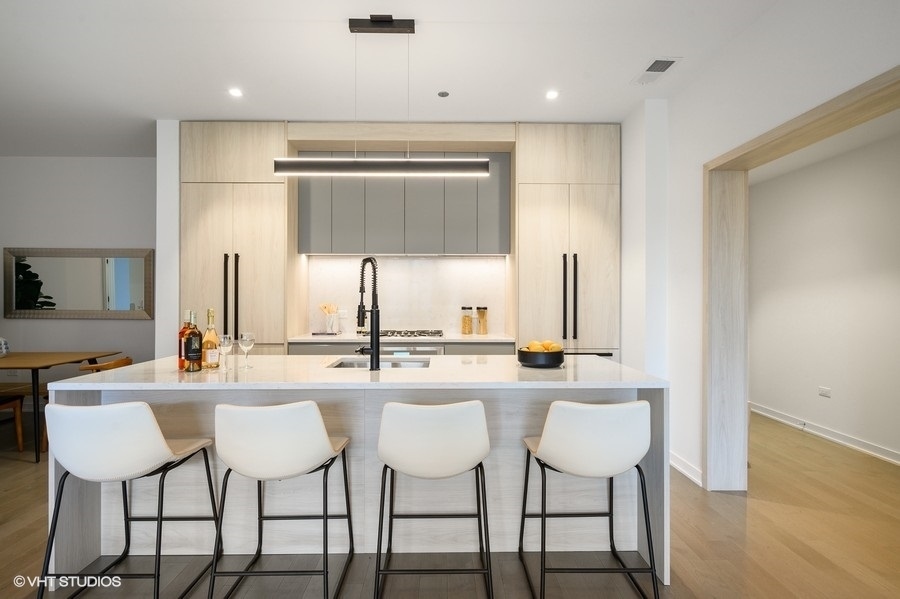 1400 West Monroe Street, Unit 5F Chicago, IL 60607 - Photo 5 of 25 a kitchen with stainless steel appliances kitchen island a large window and chairs