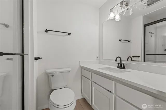 a bathroom with a granite countertop toilet sink and mirror