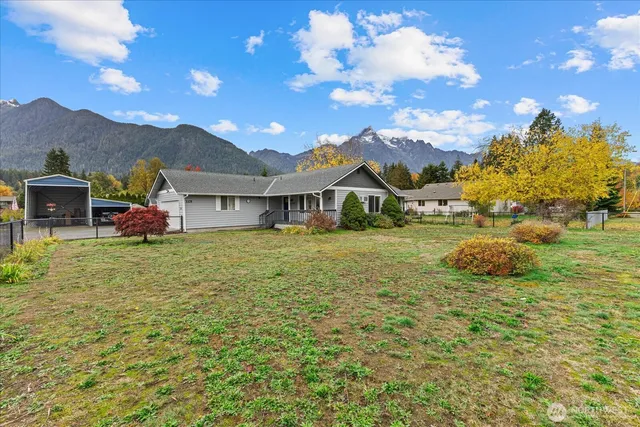 a front view of house with yard and mountain
