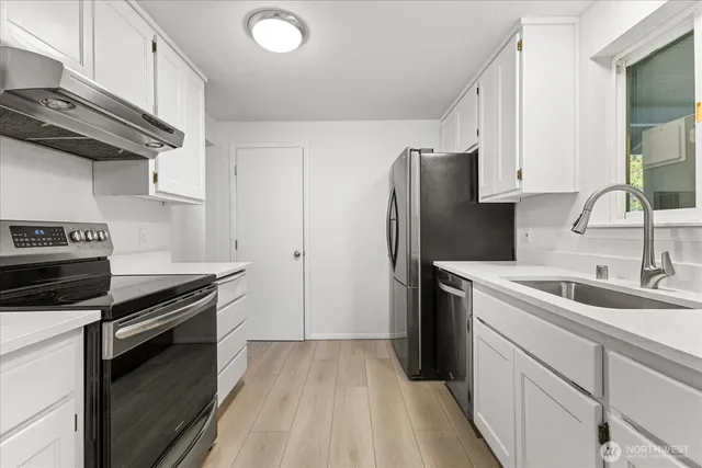 a kitchen with a sink appliances and cabinets