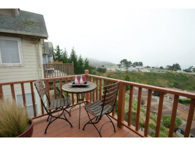 538 Monterey Road, Unit B Pacifica, CA 94044 - Photo 8 of 25 a balcony with wooden floor table and chairs