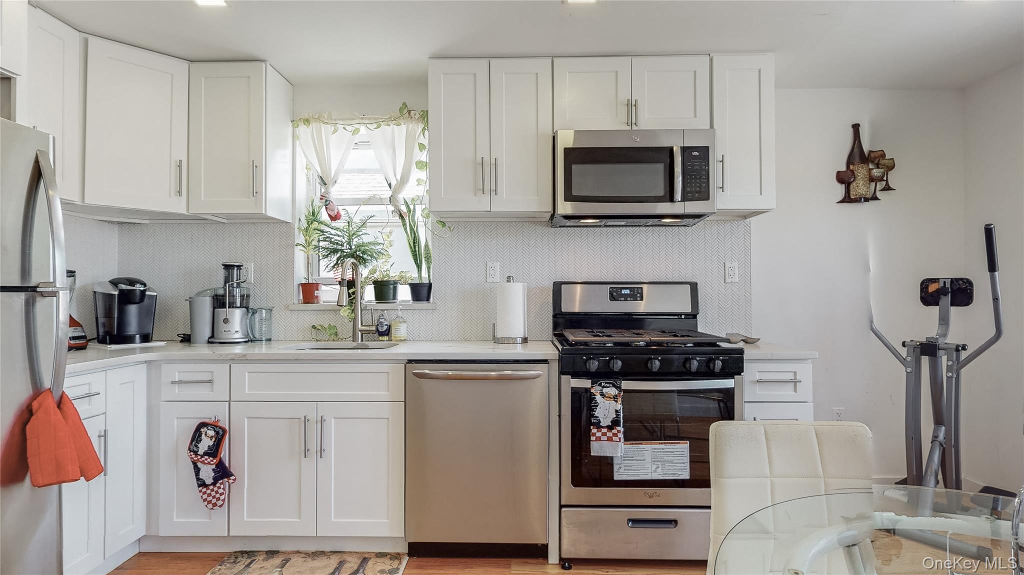 138-07 232nd Street Queens, NY 11413 - Photo 5 of 15 a kitchen with stainless steel appliances granite countertop a stove a microwave and cabinets