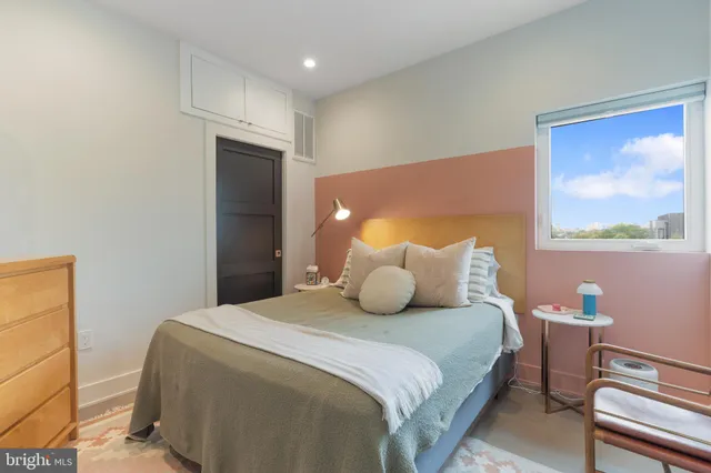 a bedroom with a bed and a painting on the wall