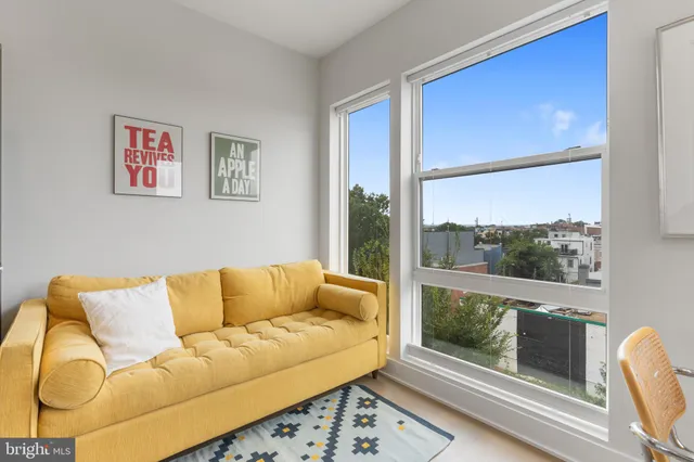 a living room with furniture and a floor to ceiling window