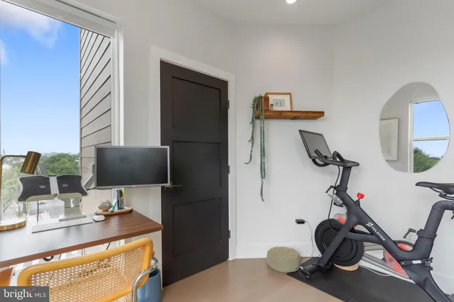 a view of a workspace with furniture and gym equipment