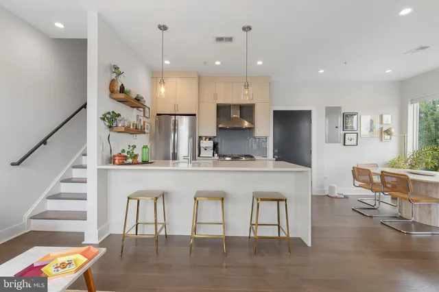 a large white kitchen with lots of counter space dining table and chairs