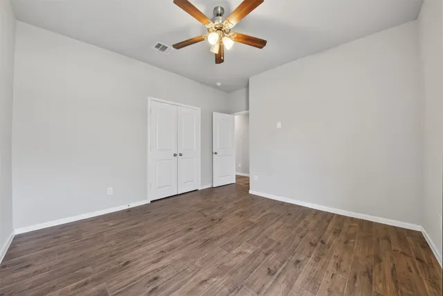a view of an empty room with window and wooden floor