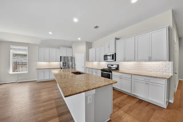 a kitchen with granite countertop a stove and a sink