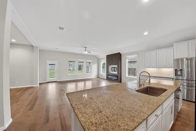 a kitchen with granite countertop a sink and a refrigerator