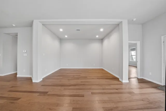 a view of empty room with wooden floor