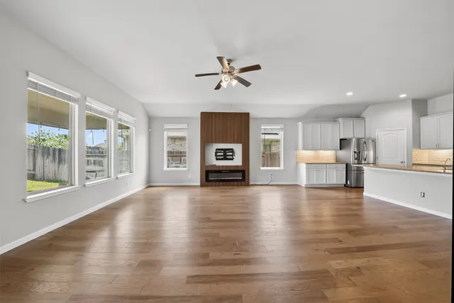 a view of empty room with wooden floor and windows