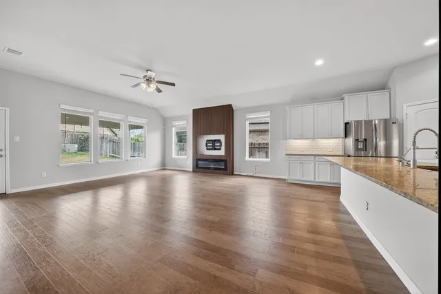 a view of an empty room with a window and wooden floor