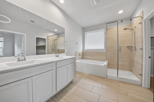 a spacious bathroom with a shower a sink and a mirror