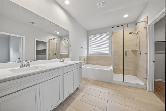 a spacious bathroom with a shower a sink and mirror
