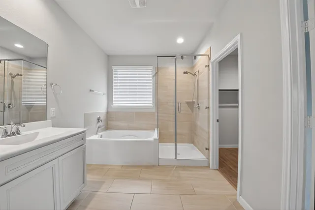 a spacious bathroom with a bathtub sink and mirror