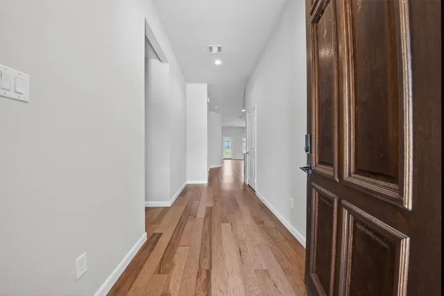 a view of a hallway with wooden floor