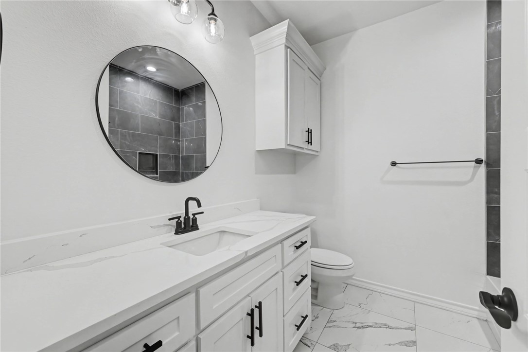 118 Amethyst Street Portland, TX 78374 - Photo 26 of 39 a bathroom with a sink a toilet and a mirror