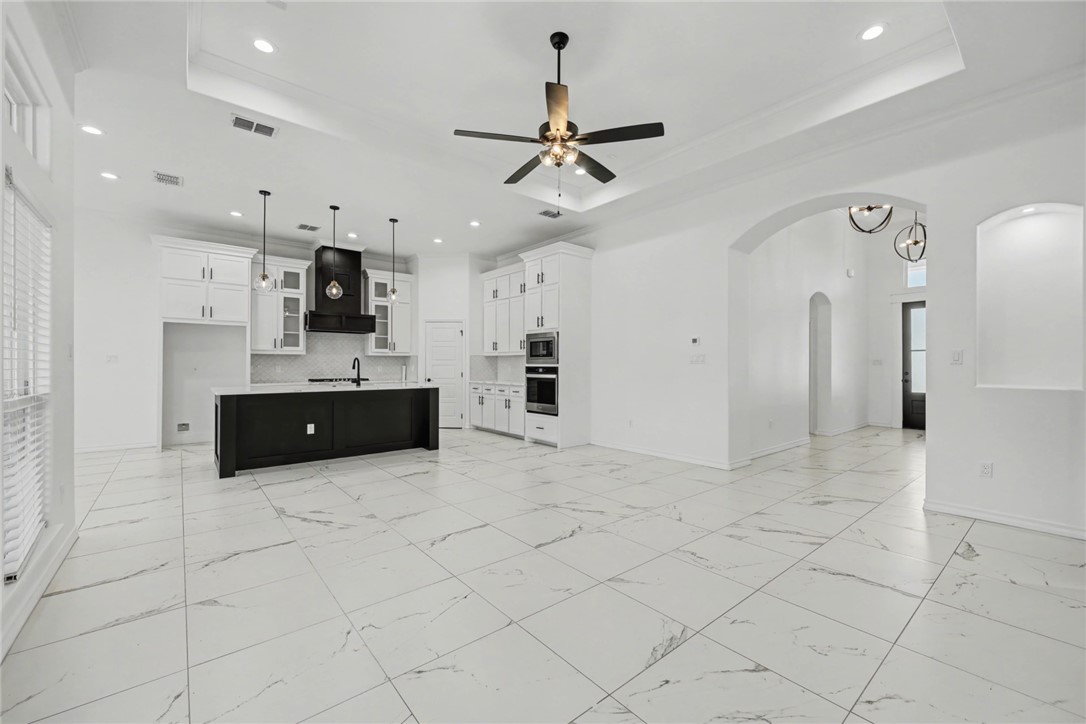 118 Amethyst Street Portland, TX 78374 - Photo 7 of 39 a large white kitchen with cabinets and a fireplace