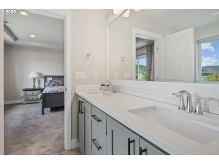 a en suite bathroom with a double vanity sink and mirror