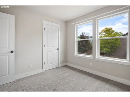 a bedroom with a bed a large window and a book shelf