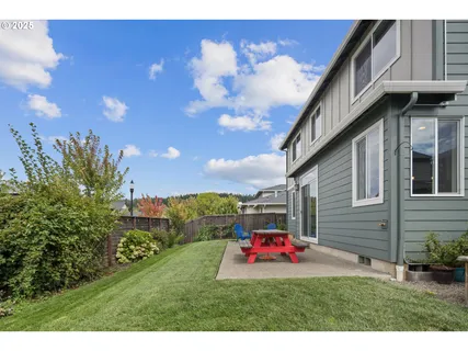 a backyard of a house with table and chairs