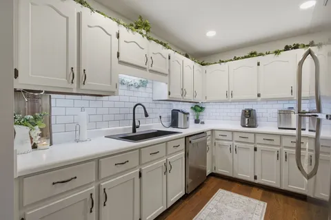 a kitchen with white cabinets and a sink